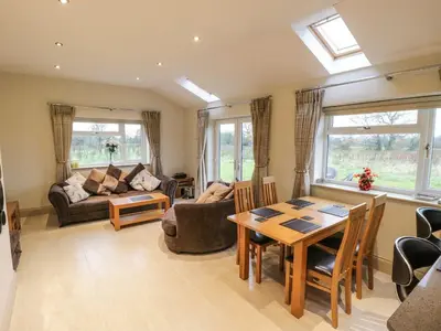 a living room with a table and a couch at Shreyas Cottage in Blackburn