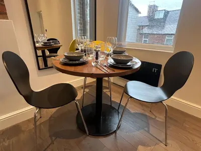 a dining room table with chairs and wine glasses at Liverpool Willow House - 4 Bed Close to Anfield Stadium in Liverpool