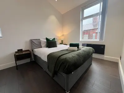 a bedroom with a large bed and a window at Liverpool Willow House - 4 Bed Close to Anfield Stadium in Liverpool