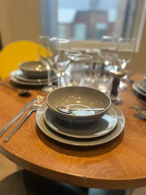 a table with plates and silverware on a wooden table at Liverpool Willow House - 4 Bed Close to Anfield Stadium in Liverpool