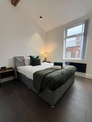 a bedroom with a large bed and a window at Liverpool Willow House - 4 Bed Close to Anfield Stadium in Liverpool