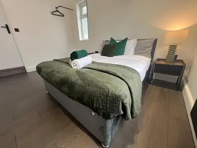 a bedroom with a large bed with green pillows at Liverpool Willow House - 4 Bed Close to Anfield Stadium in Liverpool