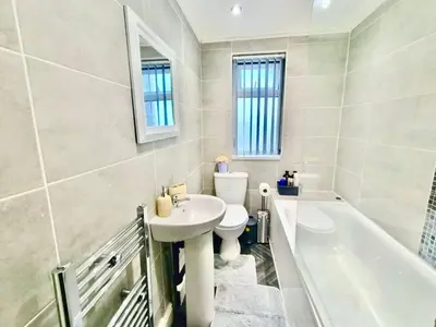 a bathroom with a sink and a toilet and a bath tub at Cosy 4 Bedroom Liverpool Contractor & Family Stay in Liverpool