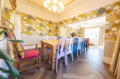 a dining room with a wooden table and blue chairs at Crookdale House By Holiday Heim Country Manor With Private Pool And Bar in Preesall