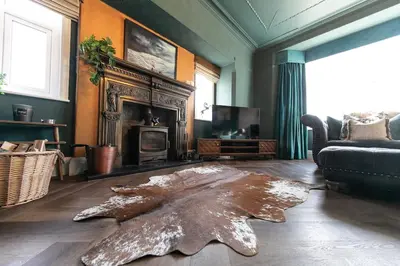a living room with a large animal skin rug on the floor at Crookdale House By Holiday Heim Country Manor With Private Pool And Bar in Preesall