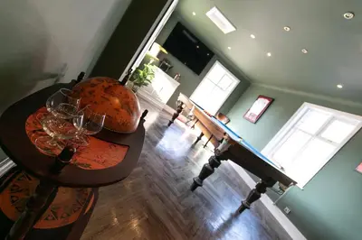 a dining room with a table with wine glasses on it at Crookdale House By Holiday Heim Country Manor With Private Pool And Bar in Preesall