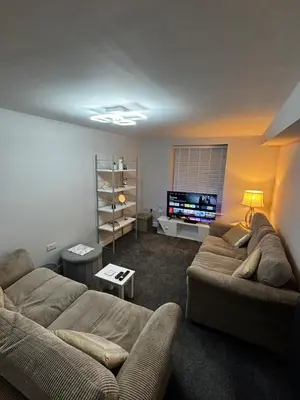 a living room with two couches and a flat screen tv at Spacious Modern flat Blackburn in Blackburn