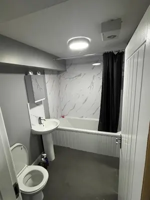 a bathroom with a toilet and a tub and a sink at Spacious Modern flat Blackburn in Blackburn