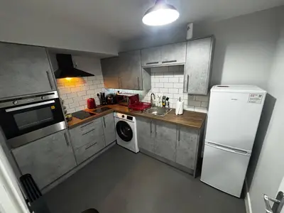 a kitchen with a white refrigerator and a washing machine at Spacious Modern flat Blackburn in Blackburn