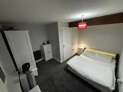 a bedroom with a white bed and a red light at Spacious Modern flat Blackburn in Blackburn