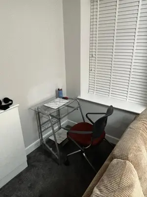 a glass table and a chair in a room at Spacious Modern flat Blackburn in Blackburn