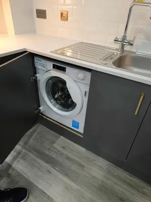 a washing machine in a kitchen next to a sink at Preston City centre Winckley Square Flat in Preston
