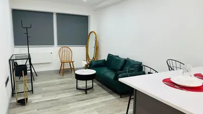 a living room with a green couch and a table at Preston City centre Winckley Square Flat in Preston