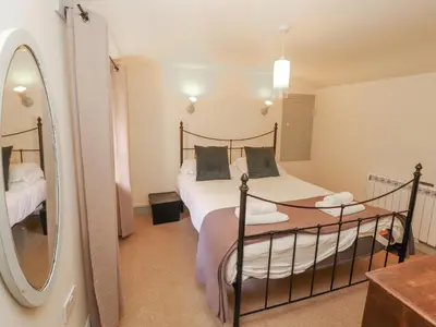 a bedroom with a bed and a mirror at Rock Cottage in Milnthorpe