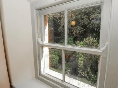 an open window with a view of a garden at Rock Cottage in Milnthorpe