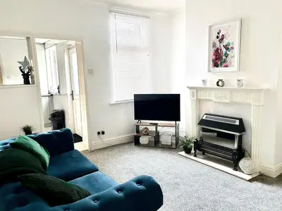 a living room with a blue couch and a fireplace at Wordsworth House by Sapphire Properties -Near to BAE Systems in Barrow in Furness