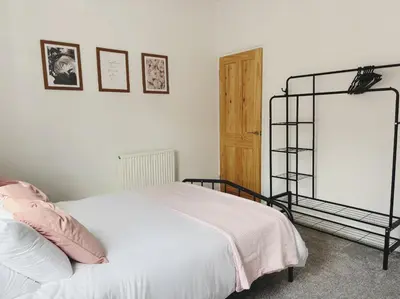 a bedroom with a white bed and a wooden door at Wordsworth House by Sapphire Properties -Near to BAE Systems in Barrow in Furness