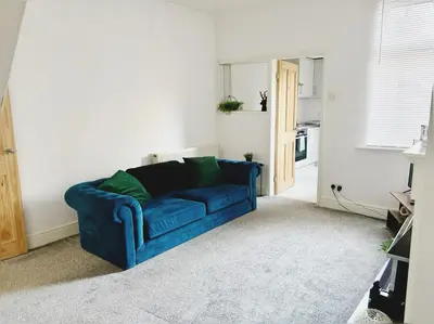 a blue couch sitting in a living room at Wordsworth House by Sapphire Properties -Near to BAE Systems in Barrow in Furness