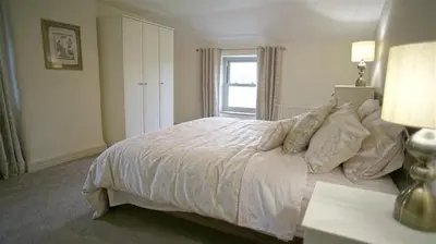 a bedroom with a white bed with a window at Tunstall Ing Farmhouse - Duchy of Lancaster Estate in Whitewell