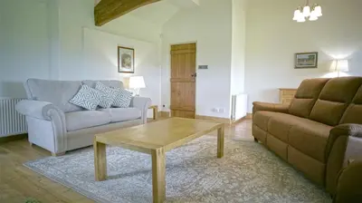 a living room with a couch and a coffee table at Tunstall Ing Farmhouse - Duchy of Lancaster Estate in Whitewell