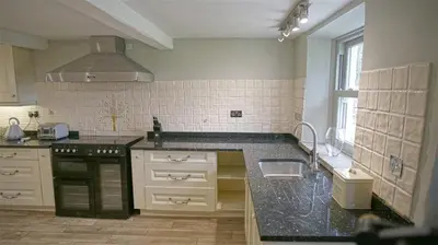 a kitchen with a black counter top and a sink at Tunstall Ing Farmhouse - Duchy of Lancaster Estate in Whitewell