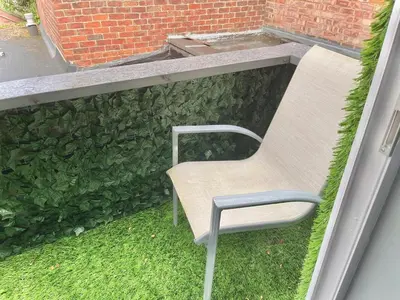 a chair sitting in the grass outside a window at Ideal pay-as-you-stay 1-bed apartment in Preston in Preston