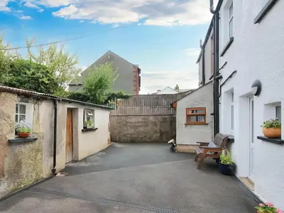 a courtyard in a house with a bench in it at Paddy's Cottage in Flookburgh