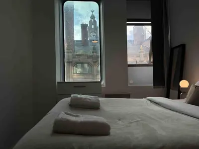 a bedroom with a bed with a view of a city at 65 Inch TV City Center 1BR Long Stay Ready in Liverpool