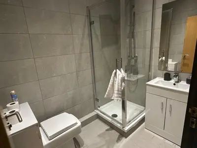 a bathroom with a shower and a toilet and a sink at 65 Inch TV City Center 1BR Long Stay Ready in Liverpool