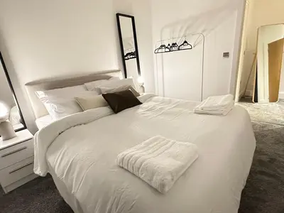 a bedroom with a white bed with a white blanket at 65 Inch TV City Center 1BR Long Stay Ready in Liverpool