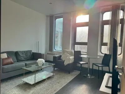 a living room with a couch and a table at 65 Inch TV City Center 1BR Long Stay Ready in Liverpool