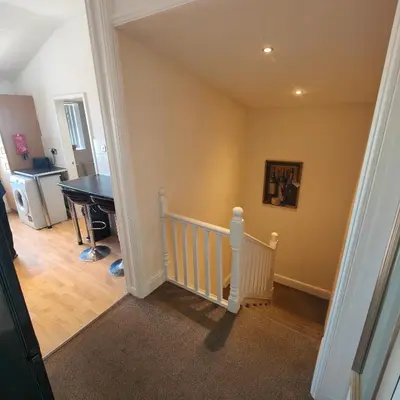 a room with a staircase with a table and a table at Home from home - 2 bedroom apartment in Liverpool