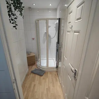 a small bathroom with a shower and a door at Home from home - 2 bedroom apartment in Liverpool