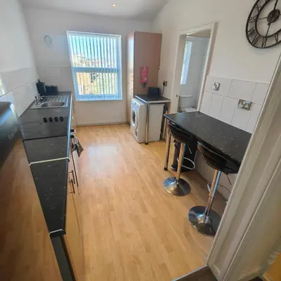 a kitchen with a table and a counter top at Home from home - 2 bedroom apartment in Liverpool
