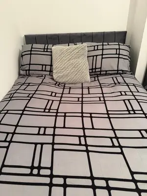 a bed with a pillow on top of it at City Apartment in Litherland
