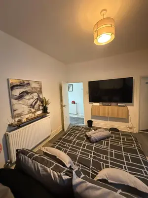 a living room with a flat screen tv and a couch at Home From Home in Liverpool