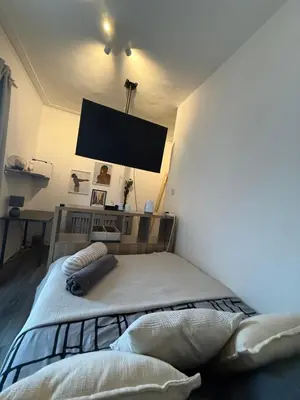 a bedroom with a bed with a tv on the wall at Home From Home in Liverpool