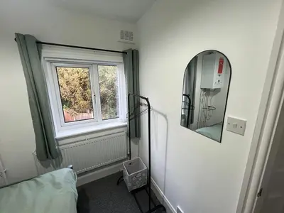 a room with a window and a mirror and a bed at Whole home Aintree Racecourse in Fazakerley