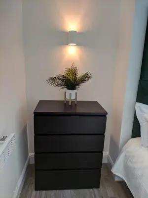 a black dresser with a plant on it in a bedroom at Dream101, Luxury 2 Bedroom apartment - free parking in Liverpool