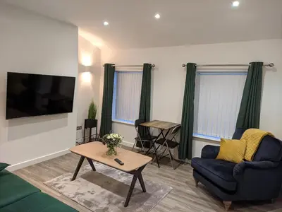 a living room with a blue couch and a table at Dream101, Luxury 2 Bedroom apartment - free parking in Liverpool