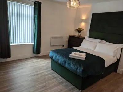 a bedroom with a large bed with two towels on it at Dream101, Luxury 2 Bedroom apartment - free parking in Liverpool