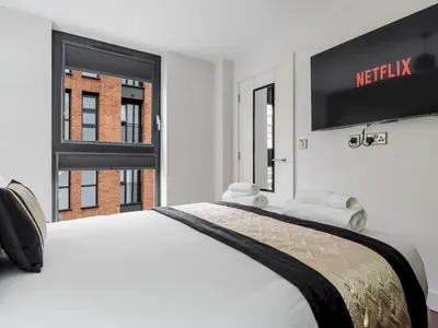 a bedroom with a white bed with a television on the wall at Pass the Keys Luxury Flat with River Views. 1 Bed. Sleeps 4 in Liverpool