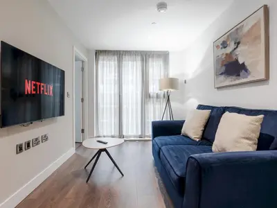 a living room with a blue couch and a tv at Pass the Keys Luxury Flat with River Views. 1 Bed. Sleeps 4 in Liverpool