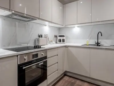 a white kitchen with white cabinets and appliances at Pass the Keys Luxury Flat with River Views. 1 Bed. Sleeps 4 in Liverpool