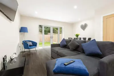 a living room with a gray couch and a blue chair at Norris Stays - Sleeps 7 by M55 in Preston