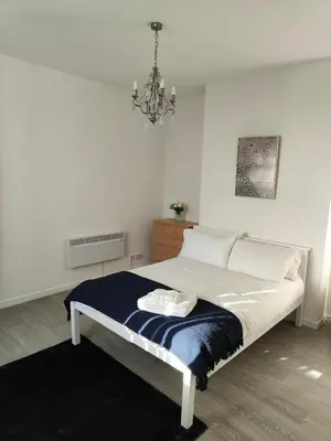 a bedroom with a bed and a chandelier at Home sweet Home, 2 bedrooms apartment in Liverpool