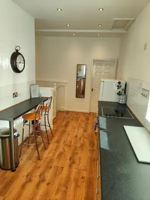 a kitchen with a counter and a table and a clock at Home sweet Home, 2 bedrooms apartment in Liverpool