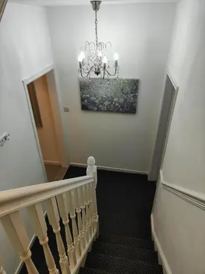 a staircase with a chandelier and a painting on the wall at Home sweet Home, 2 bedrooms apartment in Liverpool