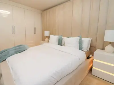 a bedroom with a large white bed and white cabinets at Mellings Place in Carnforth