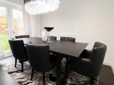 a dining room with a black table and chairs at Mellings Place in Carnforth